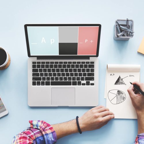 laptop and women writing on notes